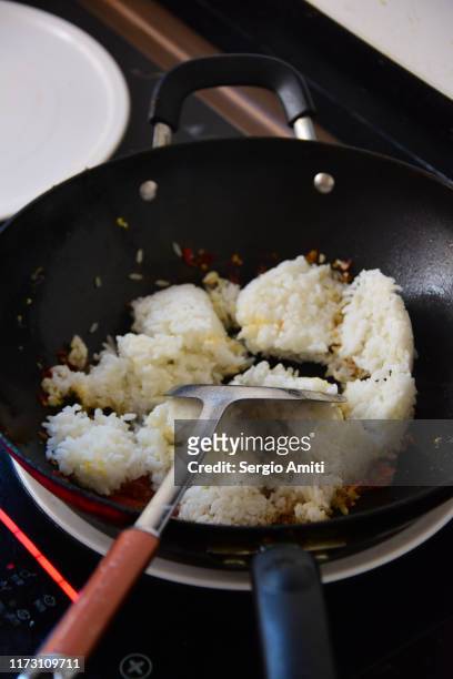 preparing chinese fried rice in a wok - fried rice stock-fotos und bilder