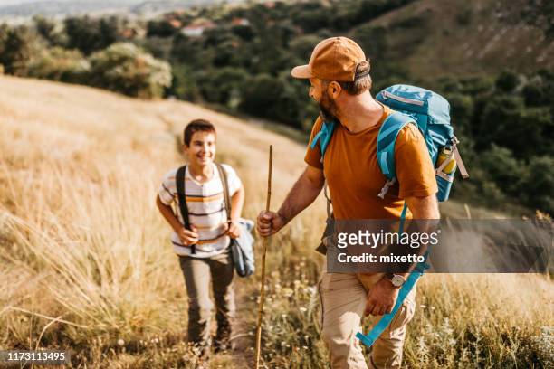 leading his son to the top of mountain - hiking mature man stock pictures, royalty-free photos & images