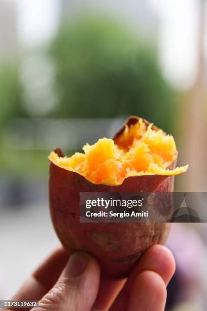half eaten roasted sweet potato - zoete aardappel stockfoto's en -beelden