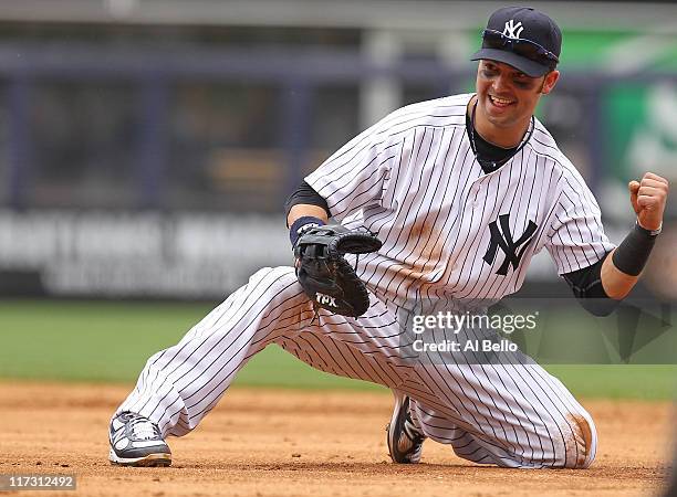 Nick Swisher of the New York Yankees celebrates after making the final out of the game by throwing out Charlie Blackmon of the Colorado Rockies...