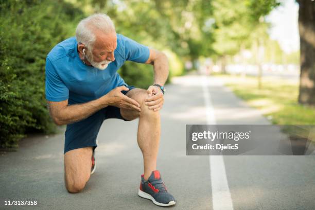 sporty senior man having a knee injury. - knee stock pictures, royalty-free photos & images