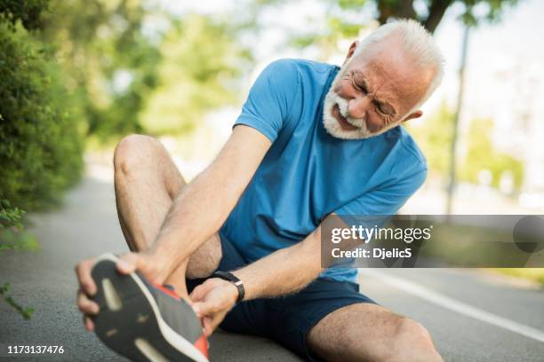 sporty senior man having leg injury outdoors. - old man feet stock pictures, royalty-free photos & images