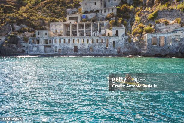 young woman kayaking in front of a pumice quarry in lipari - aeolian islands 個照片及圖片檔