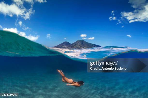 young woman swimming undersea salina island volcanoes - under water stockfoto's en -beelden