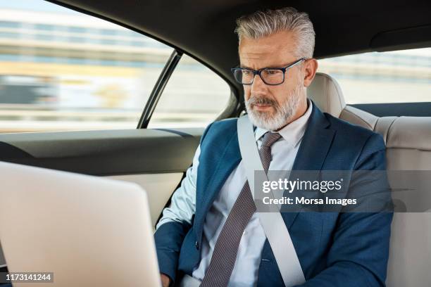 businessman using laptop in car - businessman taxi stock-fotos und bilder