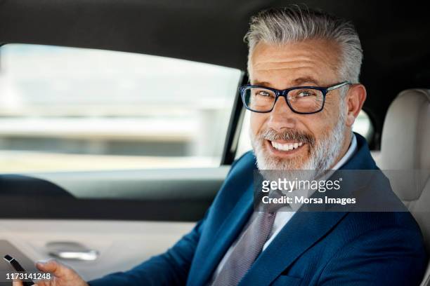 portrait of businessman traveling in car - passagerarsäte bildbanksfoton och bilder