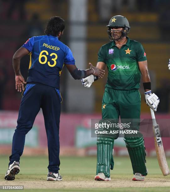 Pakistan's crickter Iftikhar Ahmed shakes hands with Sri Lanka's cricketer Nuwan Pradeep after winning the third and final one day international...