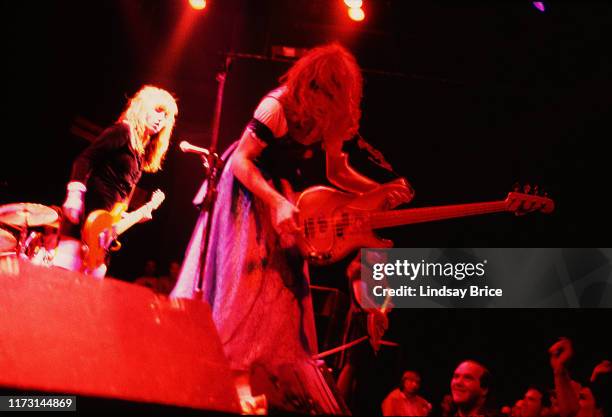 Ronnie Barnett leans over monitors toward the audience with his bass, Kim Shattuck and Melanie Vammer look on as they perform in The Muffs at the...