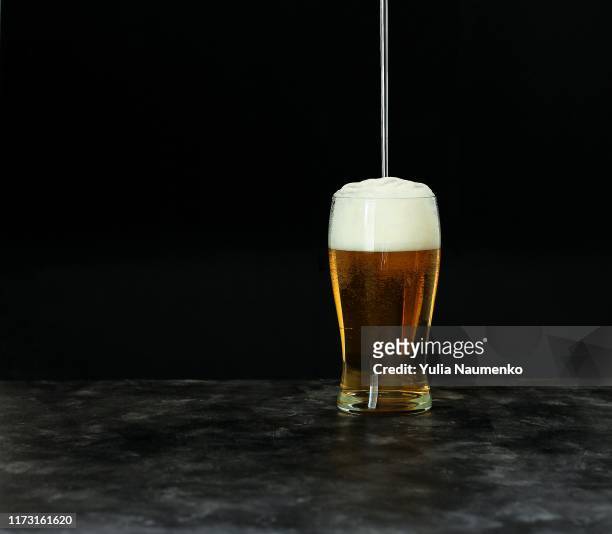 beer fest beer festival concept. cold beer with foam in glass on dark background, copy space. - beer flowing stock pictures, royalty-free photos & images