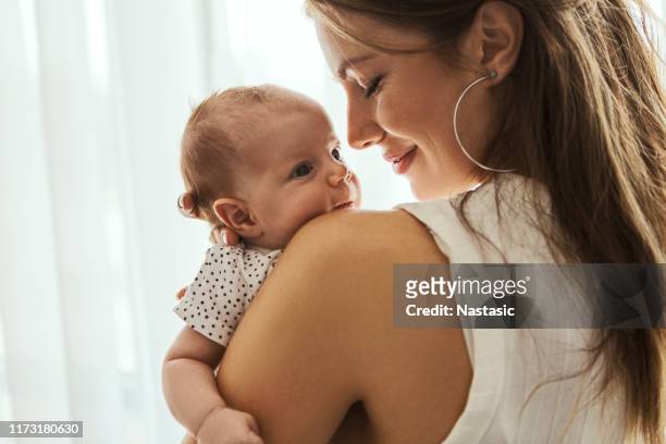 schöne mutter mit ihrem baby auf einer schulter - baby stock-fotos und bilder