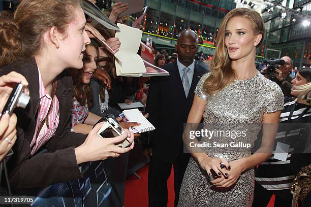 Actress Rosie Huntington-Whiteley signs autographs for fans as she attends the "Transformers 3" European premiere on June 25, 2011 in Berlin, Germany.