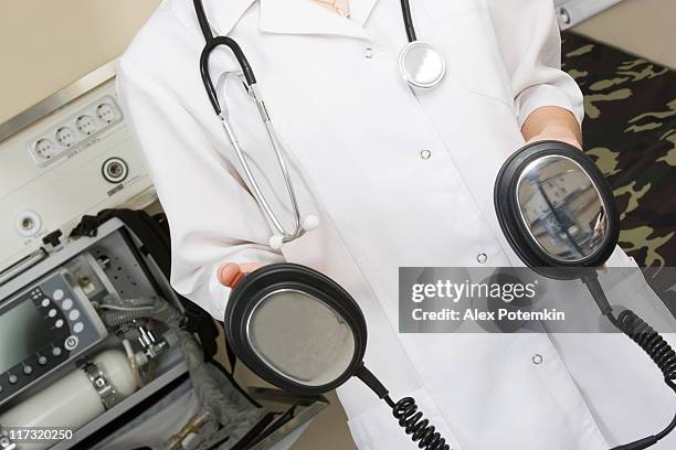 paramedic woman with defibrillator in hands - defibrillation stock pictures, royalty-free photos & images