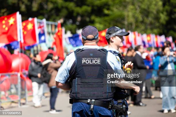 two police officers patrolling large crowd in sydney australia - australian coat of arms imagens e fotografias de stock