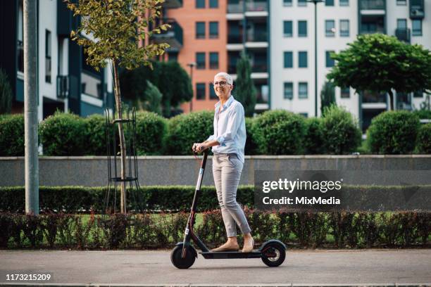 geschäftsfrau auf einem roller - nachhaltiges wirtschaften stock-fotos und bilder