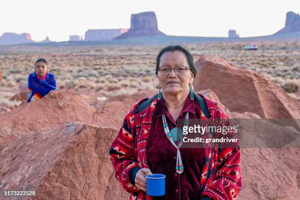 navajo grandmother and granddaughter posing together in front of the mittens rock formations in the monument valley tribal park in arizona - rural indian family stock pictures, royalty-free photos & images