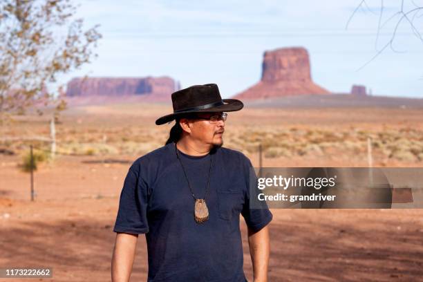 young adult native american navajo man outside in monument valley arizona - apache ethnicity stock pictures, royalty-free photos & images