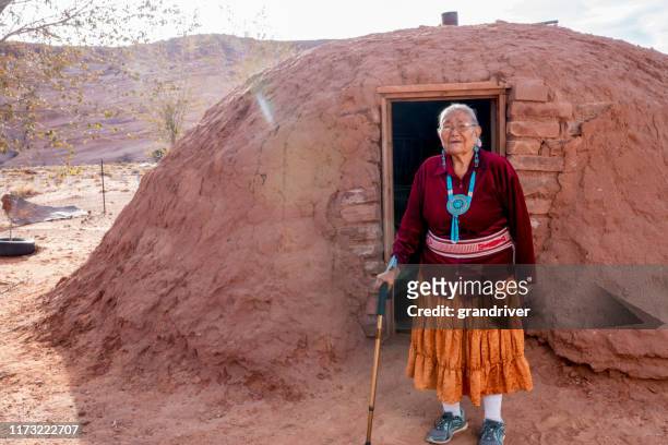 traditionele authentieke navajo oudere vrouw poseren in traditionele kleding in de buurt van een hogan in monument valley arizona - cherokee indian women stockfoto's en -beelden
