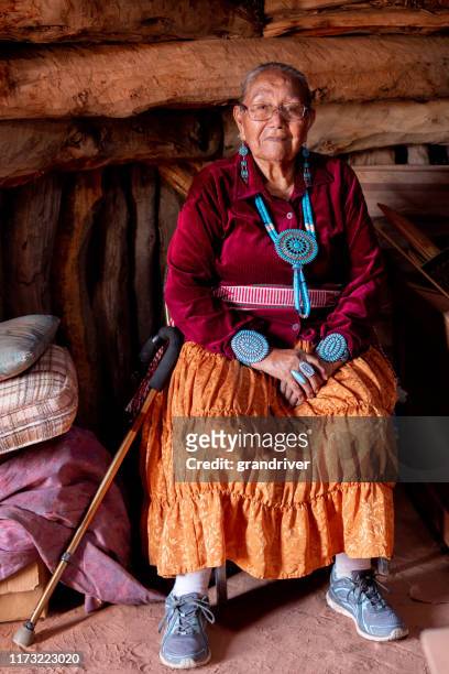 traditional authentic navajo elderly woman posing in traditional clothing in a hogan in monument valley arizona - indian jewellery stock pictures, royalty-free photos & images