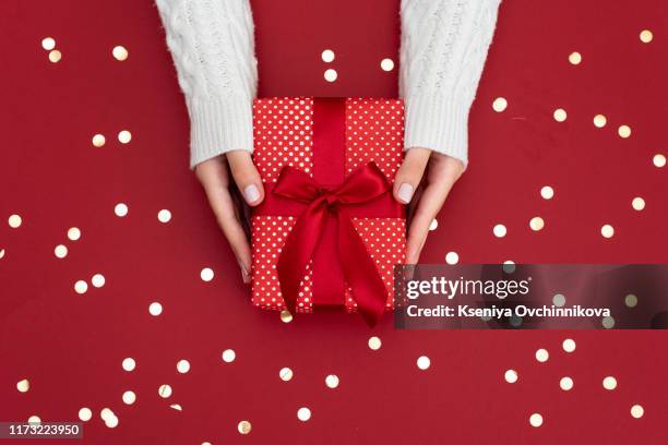 top view of female hands holding present box package in the palms isolated over flat lay background - christmas gift boxes stock pictures, royalty-free photos & images