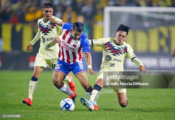 Miguel Pantoja of Club America tries to kick the ball away from Miguel Ponce of Chivas de Guadalajara during the second half of the Super Clasico...