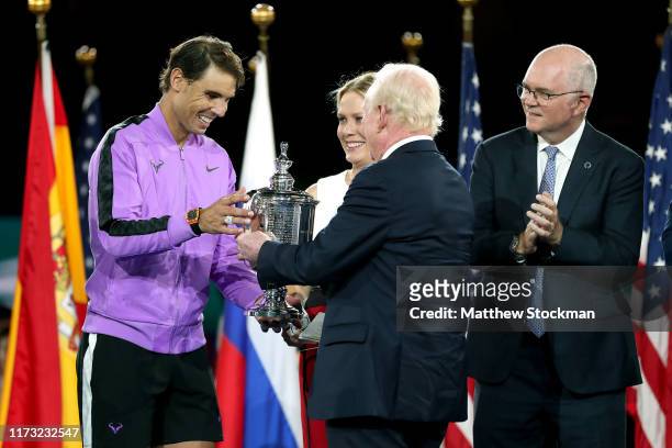Rafael Nadal of Spain is awarded with the championship trophy by Rod Laver during the trophy presentation ceremony after winning his Men's Singles...