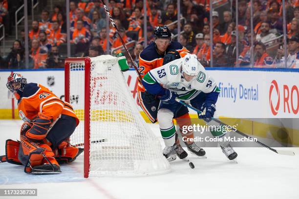 Colby Cave of the Edmonton Oilers battles behind the net with Bo Horvat of the Vancouver Canucks at Rogers Place on October 2 in Edmonton, Canada.