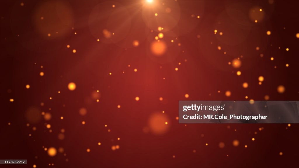 Christmas Background, De-focused Gold Colored Particles on Red Background with Lens flare
