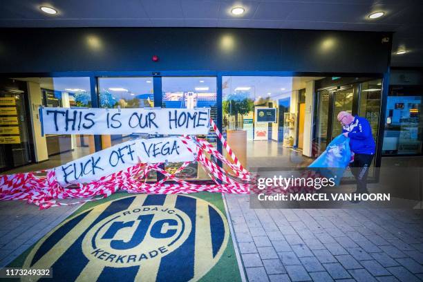 Staff member removes banners to protest against Roda JC's football club owner Mexican Mauricio Garcia de la Vega at the main entrance of Roda JC's...