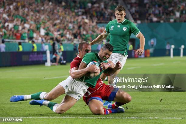 Rob Kearney of Ireland scores his side's first try despite the tackle of Denis Simplikevich of Russia during the Rugby World Cup 2019 Group A game...