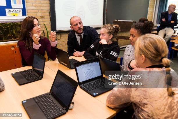 Crown Princess Mary of Denmark is talking to kids in a school class at Frydenhoejskolen near Copenhagen where the kids work with a project about...