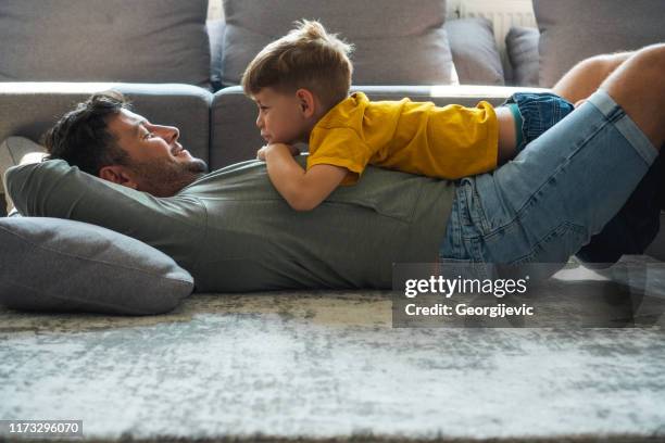 vader en zoon - playing sofa stockfoto's en -beelden