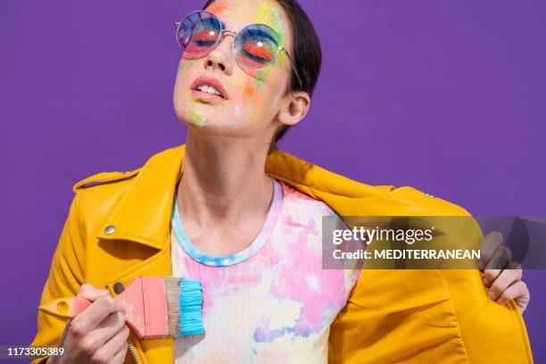 mode-künstler-maler-mädchen mit pinsel malerei selbst t-shirt auf lila - purple shirt stock-fotos und bilder