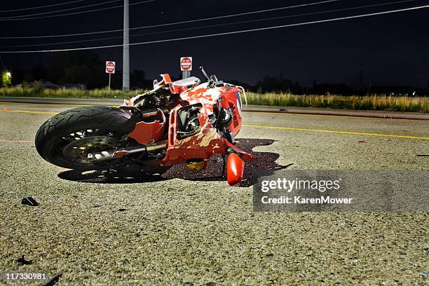 close-up of wrecked red motorcycle on side of road - collide stockfoto's en -beelden