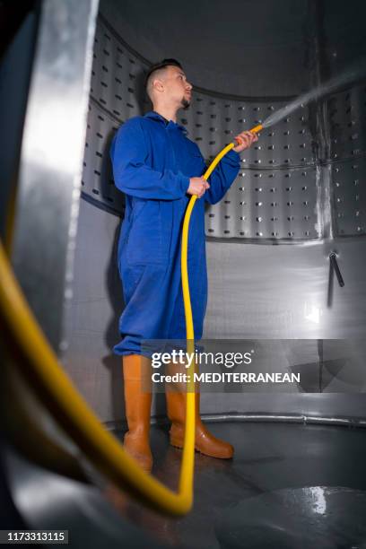 trabajador de limpieza de mangueras del tanque de bodega inoxidable - tanque de almacenamiento fotografías e imágenes de stock