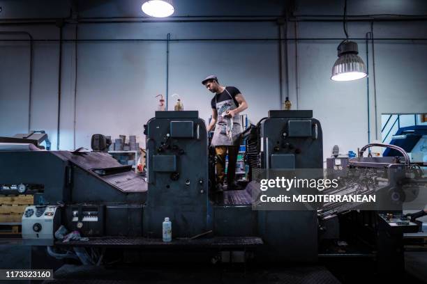 offsetdrucker-man mit 2-farben-drucker - druckerei stock-fotos und bilder