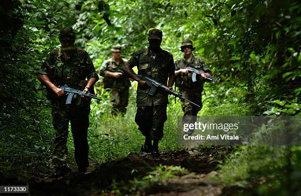 Sierra Leonian soldiers patrol alongside British troops near the border with Liberia July 22, 2002 outside the village of Buedu in Sierra Leone. On...