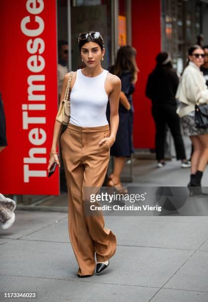Guest is seen wearing white body, brown pants outside Tibi during New York Fashion Week September 2019 on September 08, 2019 in New York City.