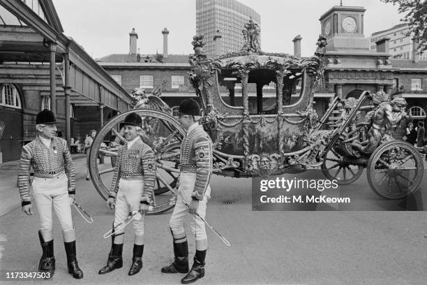 The coachmen near the Gold State Coach at the Royal Mews, Buckingham Palace, London, UK, 26th May 1965.