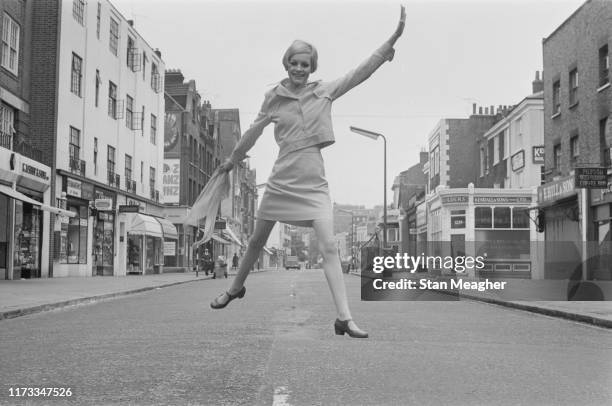English model, actress, and singer Twiggy mid-air in the middle of King's Road in Chelsea, London, UK, 13th June 1966.