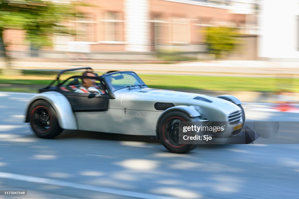 Donkervoort lightweight Dutch sports car driving at high speed on a road through a forest