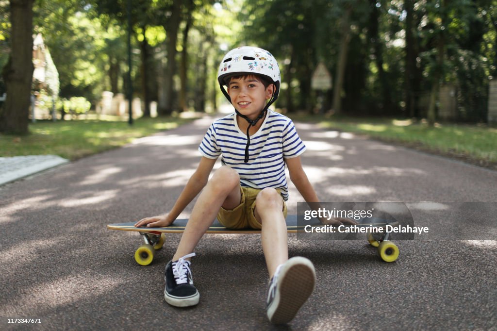 A 9 years old boy skateboarding in the street