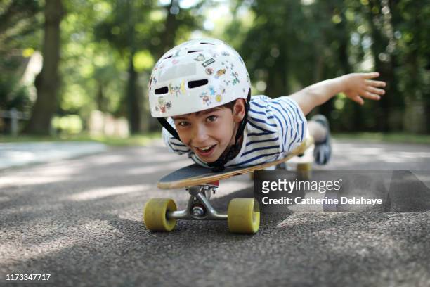 a 9 years old boy skateboarding in the street - 8 9 years stock-fotos und bilder