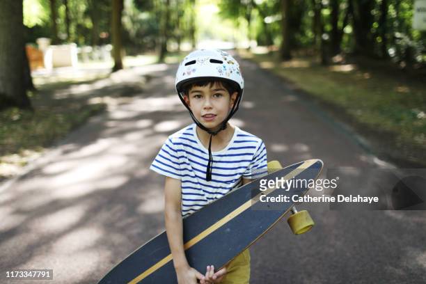 a 9 years old boy skateboarding in the street - 8 9 years stock-fotos und bilder