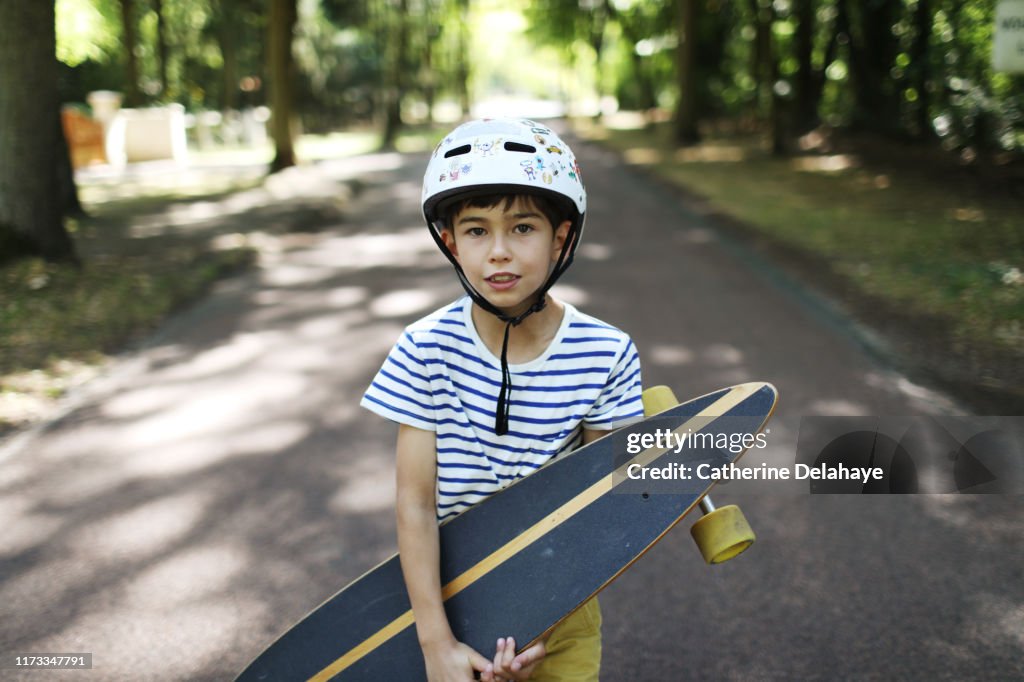 A 9 years old boy skateboarding in the street