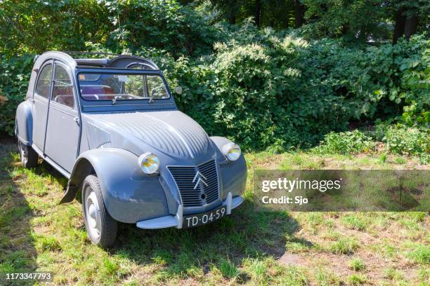 citroen 2cv french classic family car parked in a field - citroen deux chevaux stock pictures, royalty-free photos & images