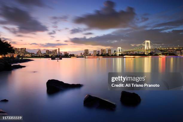 sunset over rainbow bridge, odaiba, tokyo, japan - odaiba seaside park stock pictures, royalty-free photos & images
