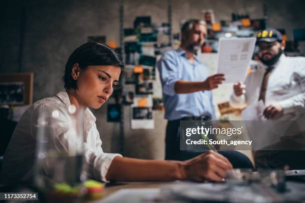 lady detective working late with colleagues - detective stock pictures, royalty-free photos & images