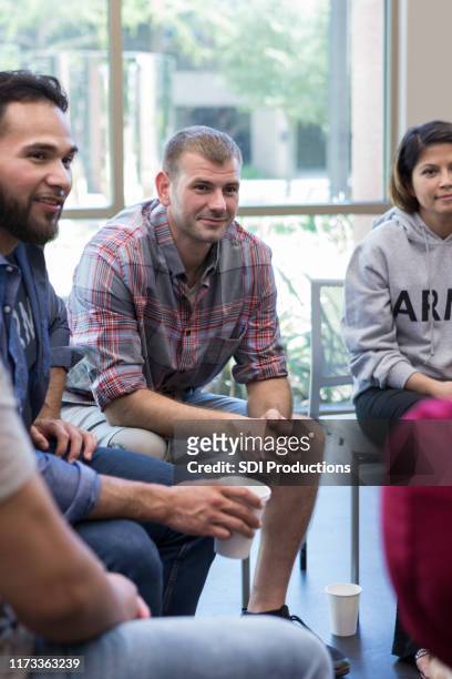 mannelijke veteraan luistert naar collega-veteraan tijdens groepstherapie sessie - meeting of the international syria support group stockfoto's en -beelden