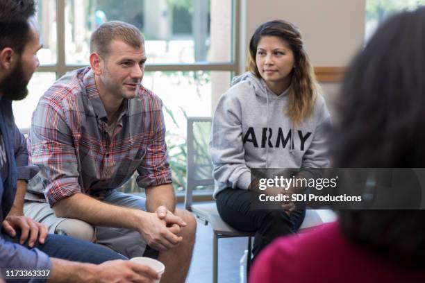vulnerable veterans talks during therapy session - veterano de guerra imagens e fotografias de stock