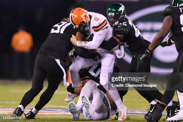 Quarterback Baker Mayfield of the Cleveland Browns is sacked by defensive end Bronson Kaufusi and defensive back Rontez Miles of the New York Jets in...